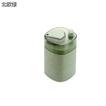 Pink and translucent automatic toothpick dispenser holder with a textured green pencil sharpener and clear lid with hex button
