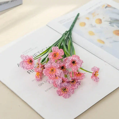 A cluster of pink and white artificial cherry blossoms with orange centers on green stems for cherry blossom wall decor