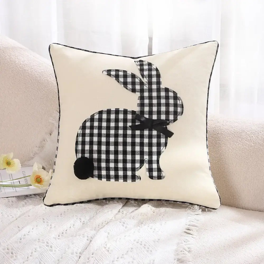 Cream-colored cushion cover with black and white checkered decorbites bunny appliqué and small black bow tie for living room decor