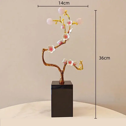 A delicate gold-toned decorbites golden tree crystal with pink and white flowers on a black base for living room decor
