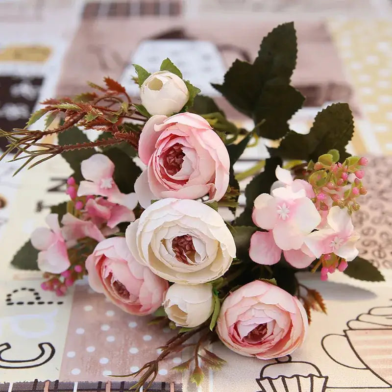 A delicate pink and white silk tea rose ranunculus bouquet with green leaves for wedding decor and autumn silk tea themes