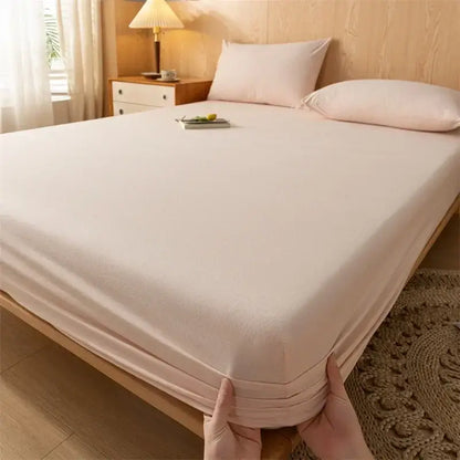 Soft pale pink cotton fitted sheet with smooth texture and elastic edge paired with plaid green beige cotton fitted sheet decorbites