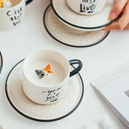 White ceramic cup with black rim and handle featuring you and me inscription and fox figurine decorbites cat claw ceramic