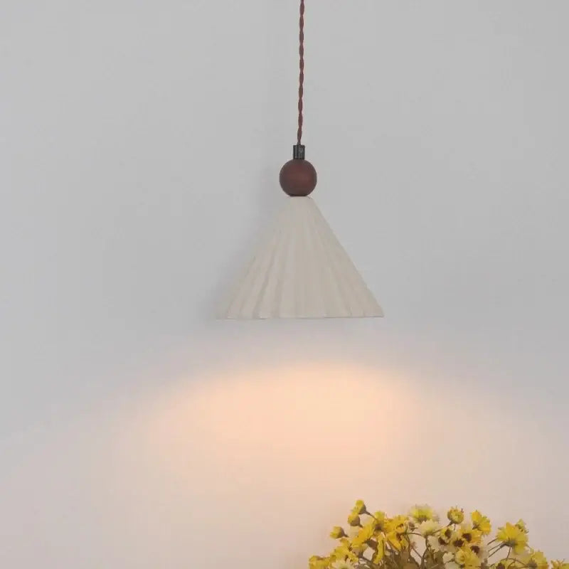 Cream-colored pleated fabric pendant light with dark brown wooden sphere and twisted copper cord decorbites ceramic wood pendant