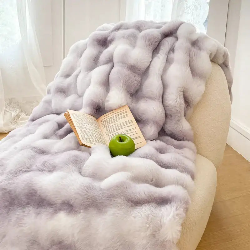 A plush cream and gradient pink double layer faux fur throw blanket draped over an armchair by decorbites gradient pink
