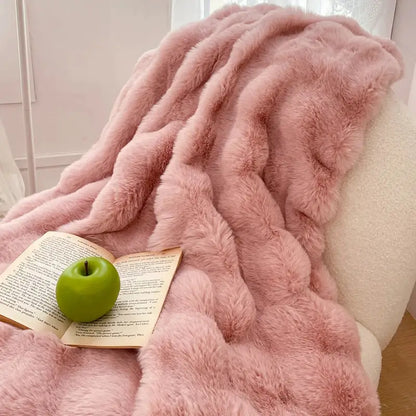 A plush cream and gradient pink double layer faux fur throw blanket draped over a chair for cozy decorbites gradient pink decor