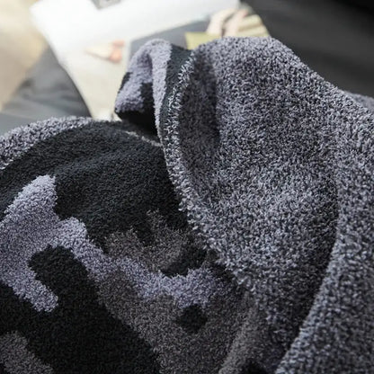 Plush dark gray and black decorbites camouflage knitted throw blanket with soft fuzzy textured surface for bedroom decor