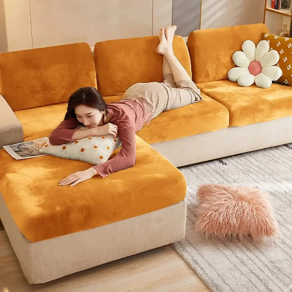 Plush orange velvet sectional sofa with beige base and decorative pillows featuring elastic cushion covers protector