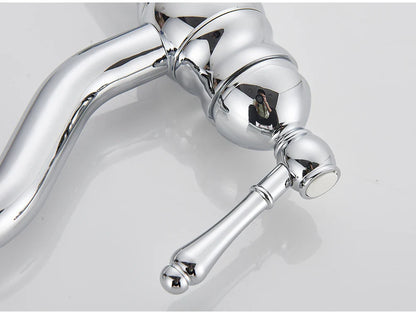 Chrome-finished single hole deck mounted vintage-style kitchen faucet with ornate curved spout and decorative handle housing material