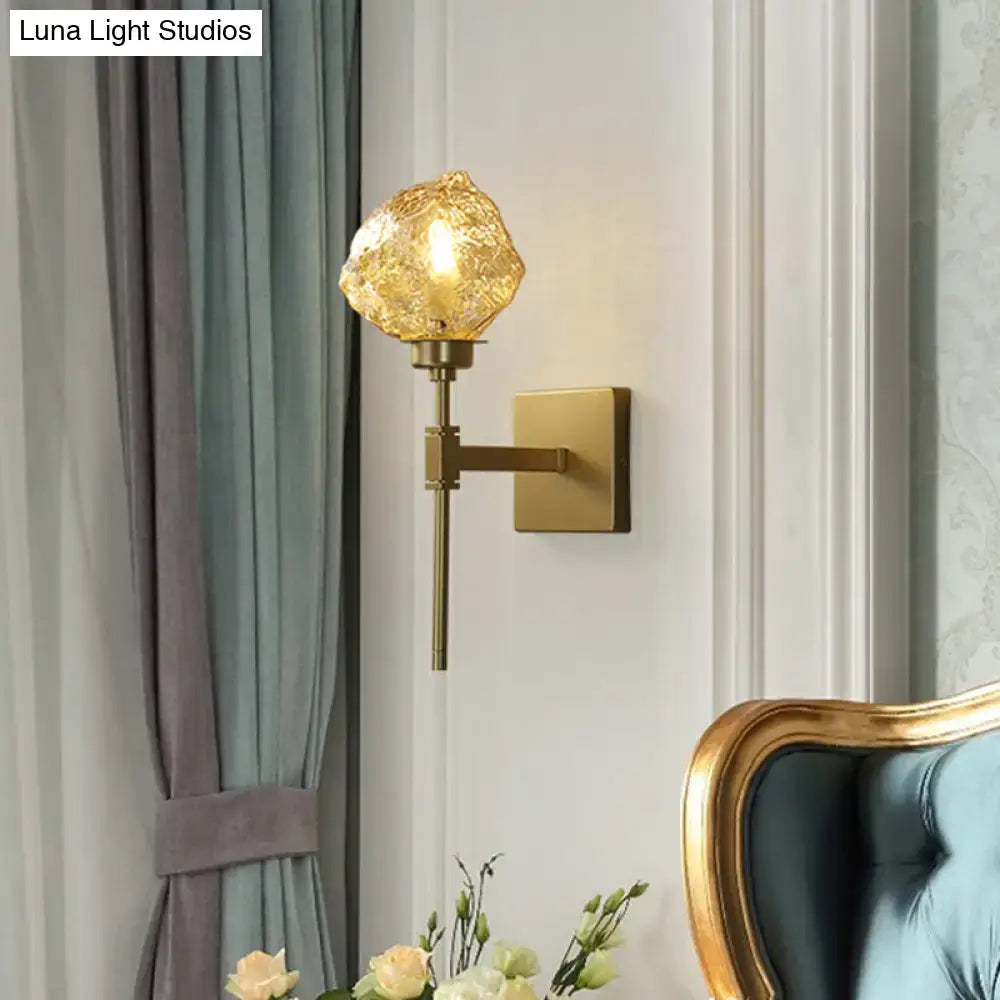 Post modern brass wall light sconce with textured amber glass globe for living room lighting