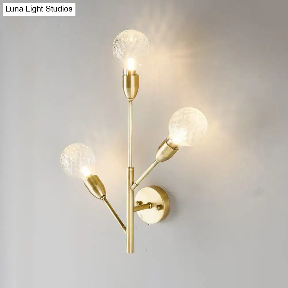 Post-modern brass wall light fixture with three clear lattice glass globe bulbs for bedroom lighting