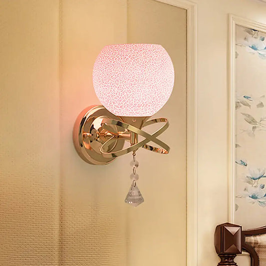 Post modern gold wall lamp with pink cracked glass globe and dangling crystal teardrop light fixture for bedroom
