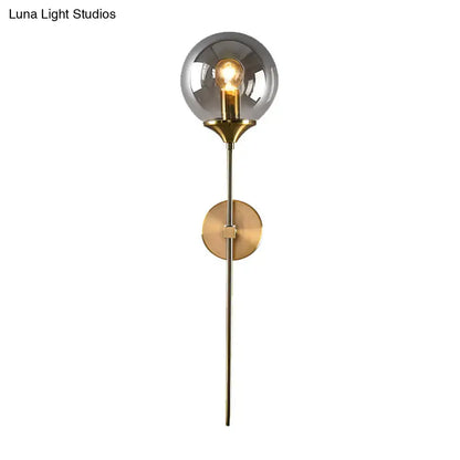 Modern wall sconce with smoke grey glass globe and brass frame compatible with e26 e27 bulb for bedroom use