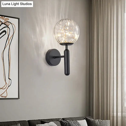Postmodern black metal wall sconce with spherical glass shade housing warm led lights for modern style bedroom lighting