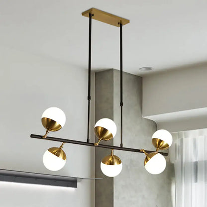 Postmodern black and gold island ceiling light with five white glass shades on polished brass fixtures for kitchen island
