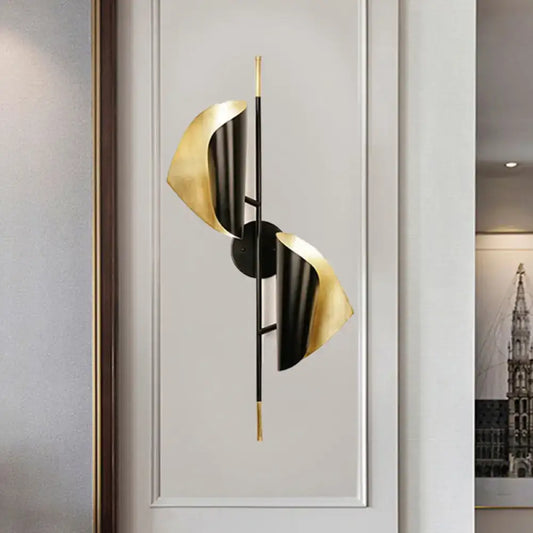 Postmodern black and gold ribbed leaf wall light with sleek metallic finish designed for staircase illumination