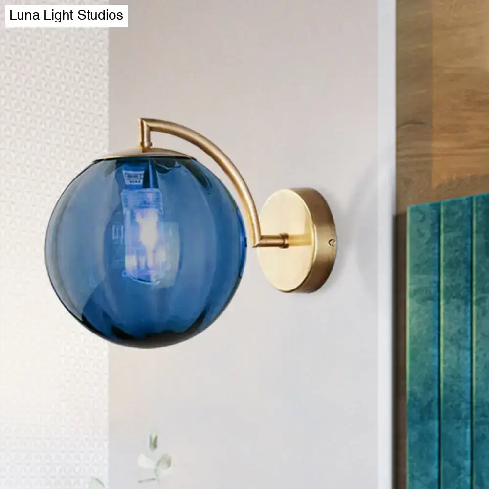 Blue spherical glass globe ball sconce with brass armed ball metal arm and mounting plate for bedroom lighting
