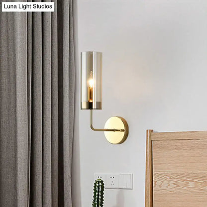 Modern postmodern brass finish wall lamp with cylindrical smoked glass shade and exposed e12 e14 bulb for bedroom use