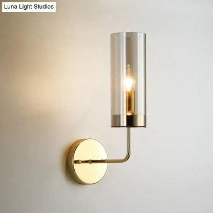 Modern brass finish wall lamp with a clear cylindrical glass shade and exposed filament bulb compatible with e12 e14