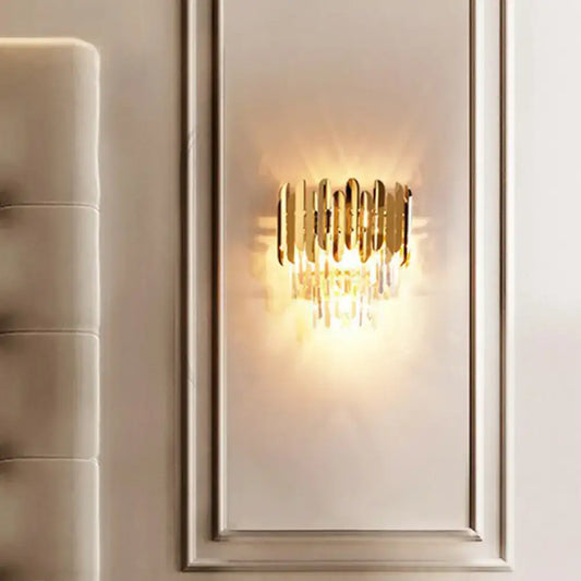 Postmodern brass tiered flush wall sconce with gold tone and vertical crystal accents for bedroom lighting