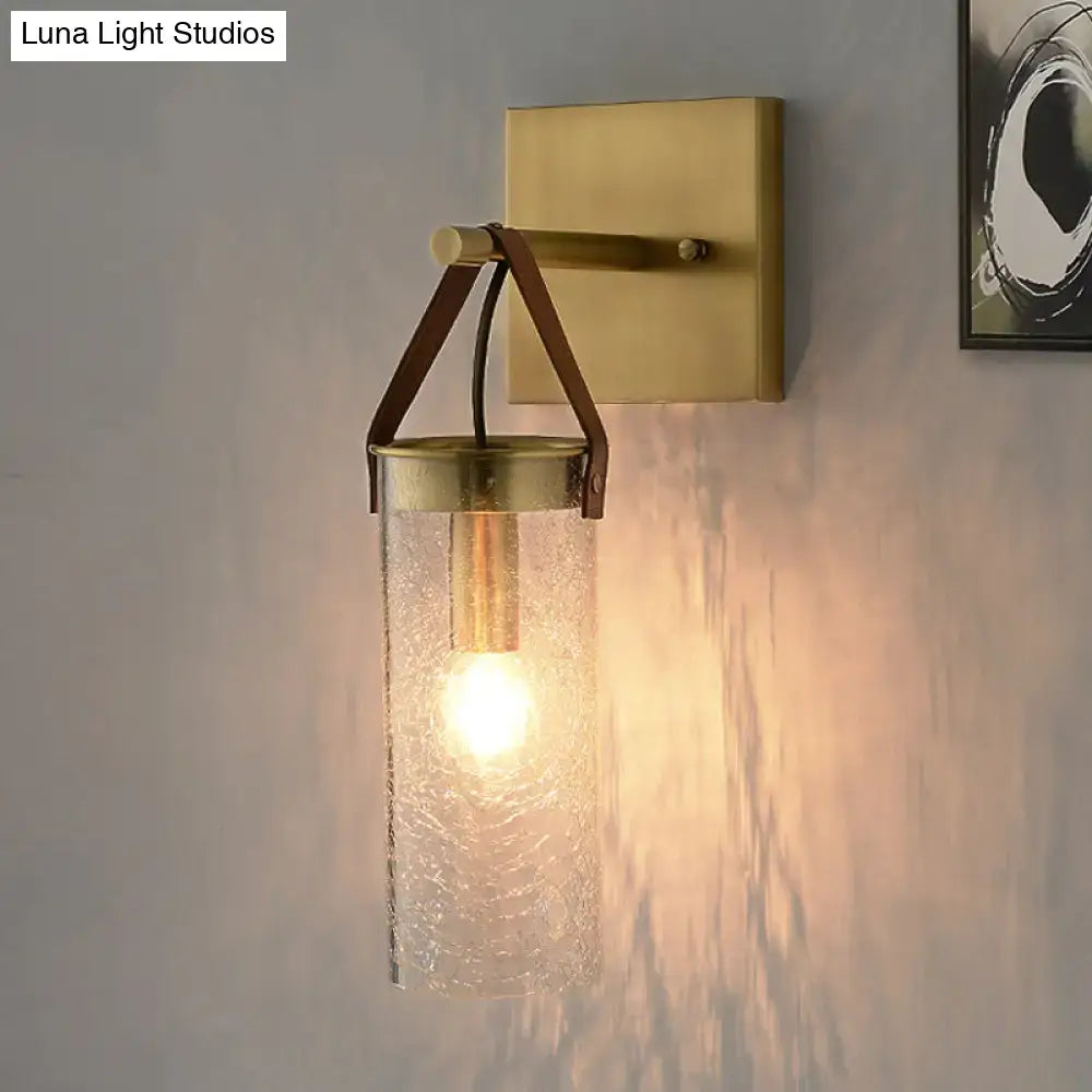 Postmodern brass wall sconce with clear crack glass cylinder and brown leather strap for dining room lighting