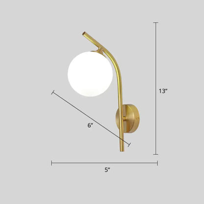 Postmodern brass wall sconce with gold-toned curved arm and white glass geometric frosted spherical shade for living room