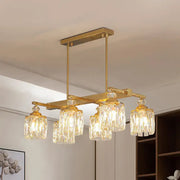Gold-toned rectangular light fixture with five crystal glass shades for modern crystal gold island lighting