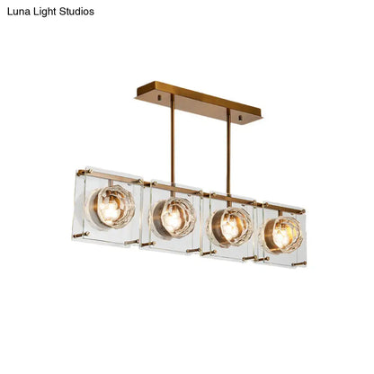 Postmodern gold and clear glass kitchen island light with four brass-finished pendant cube shades and warm bulbs