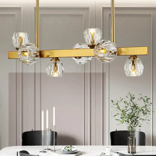 Gold-toned pendant light with clear faceted crystal globe shades featuring gold branch design for island lighting