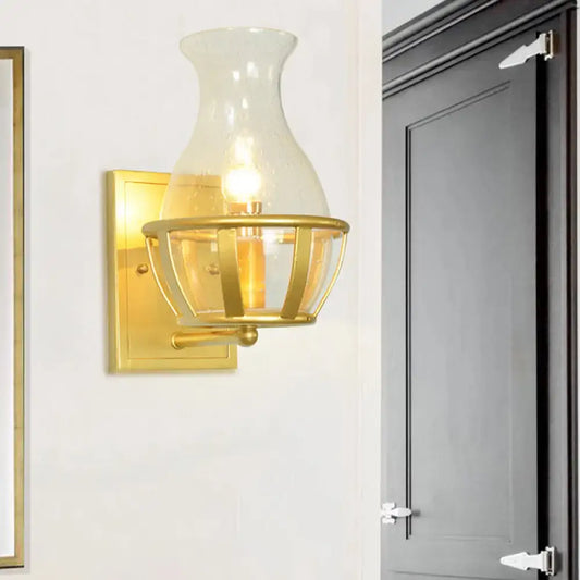 Postmodern gold clear glass wall lamp with metal frame and brass cage detailing for living room use