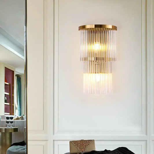 Gold-toned postmodern wall light with cascading clear glass rods for chic living space or bedroom lighting