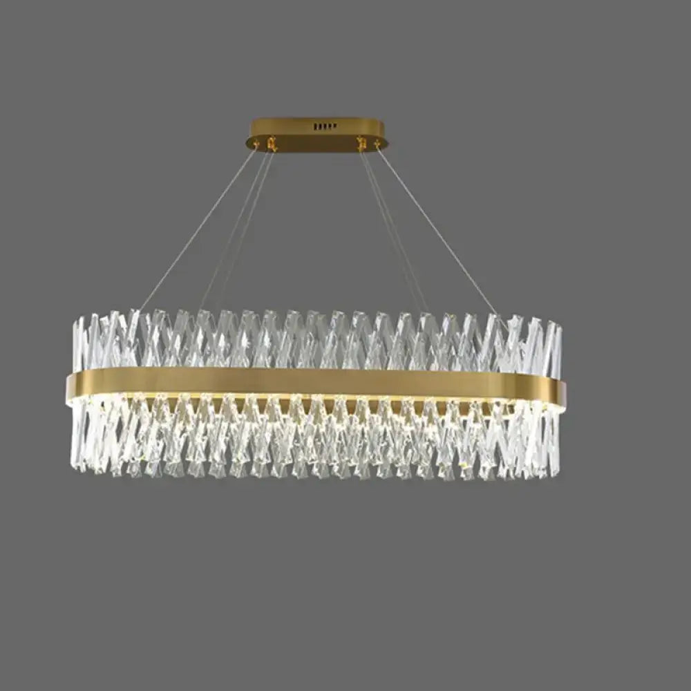 A modern oval pendant light with a gold finish frame and k9 crystal prisms for bedroom fixture width design