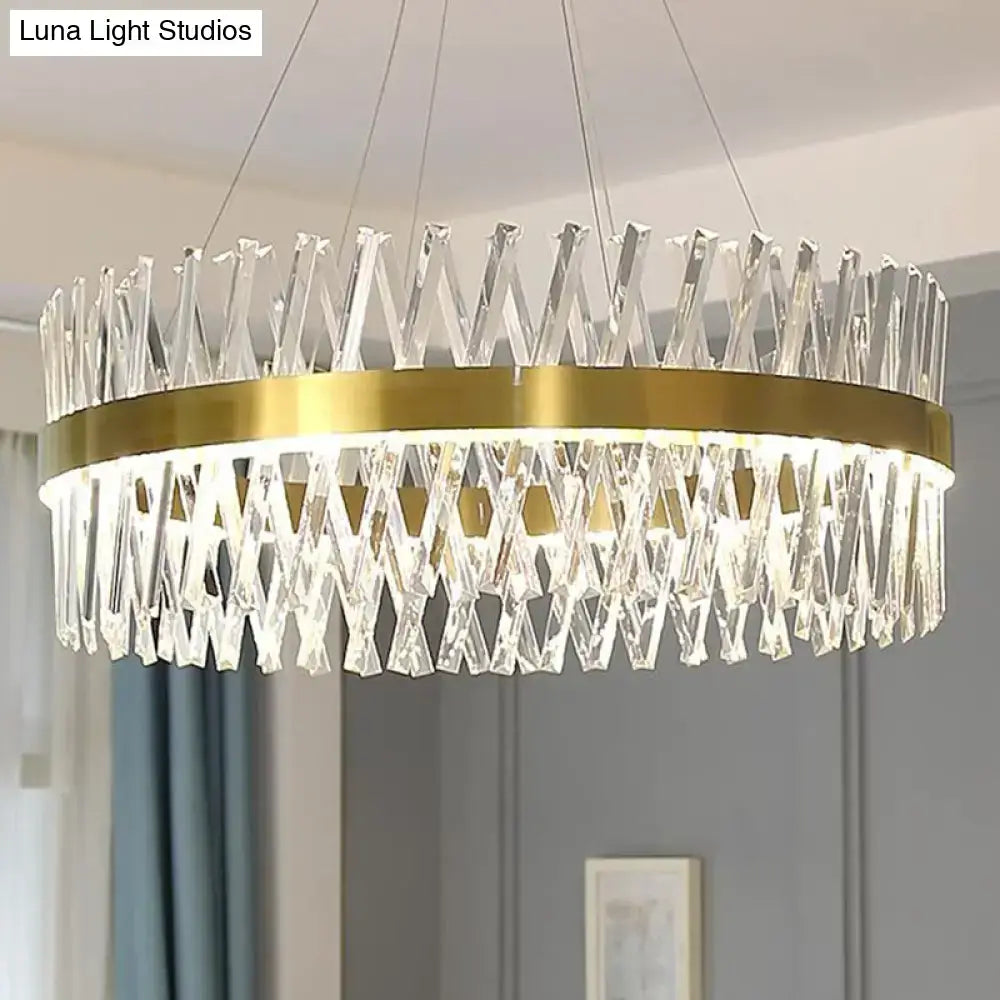 A modern pendant light with gold finish metal ring and cascading k9 crystal prisms designed for bedroom use