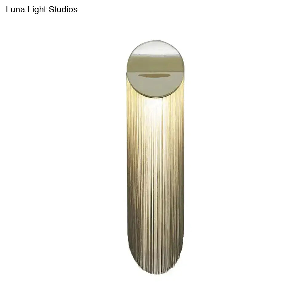 Postmodern gold fringed wall light fixture with sleek cylindrical design and cascading vertical strands for bedroom use