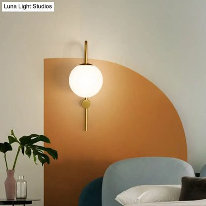 Postmodern gold wall lamp with gooseneck arm and cream glass globe in minimalist spherical metal frame
