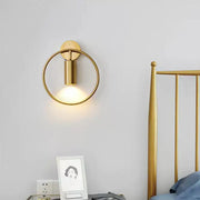 Postmodern gold-toned circular wall sconce with minimalist cylindrical light fixture and 16 inches fixture height for bedroom
