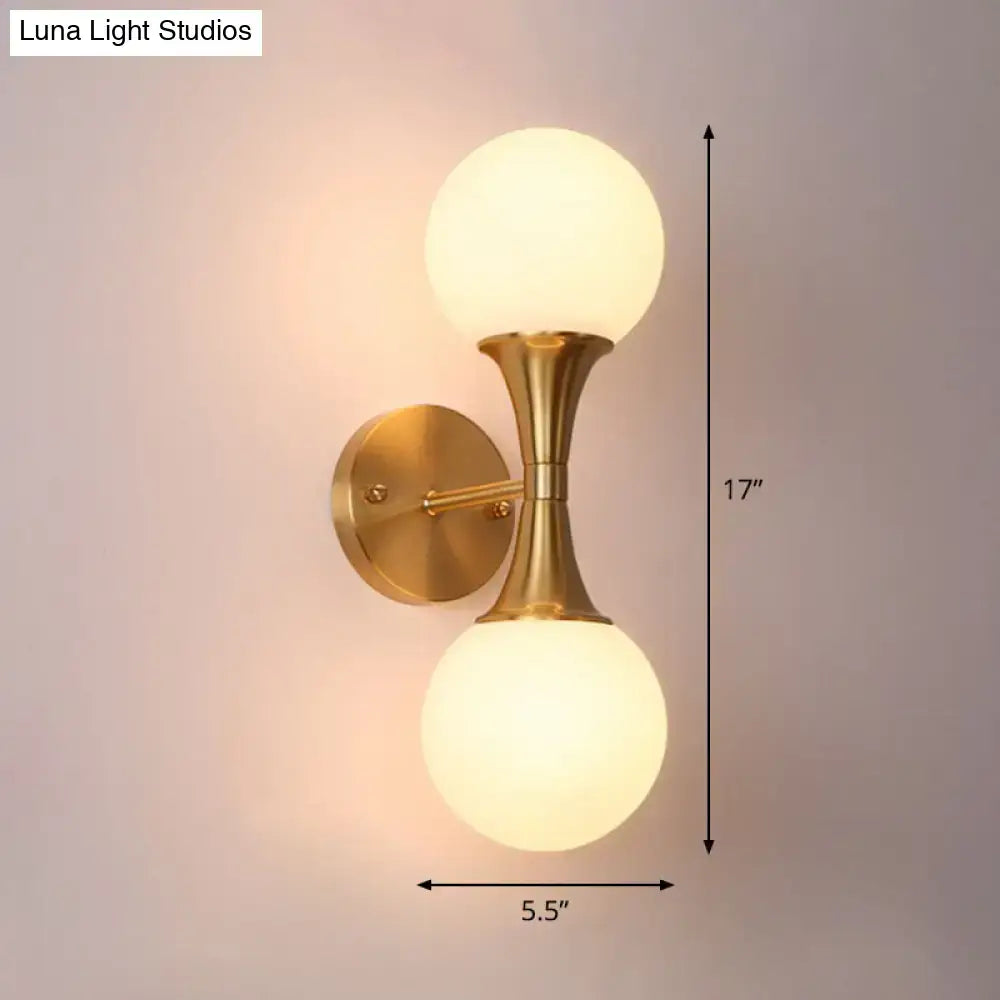 Brass-finished wall lamp with two frosted milk glass globe shades postmodern sconce light for living room