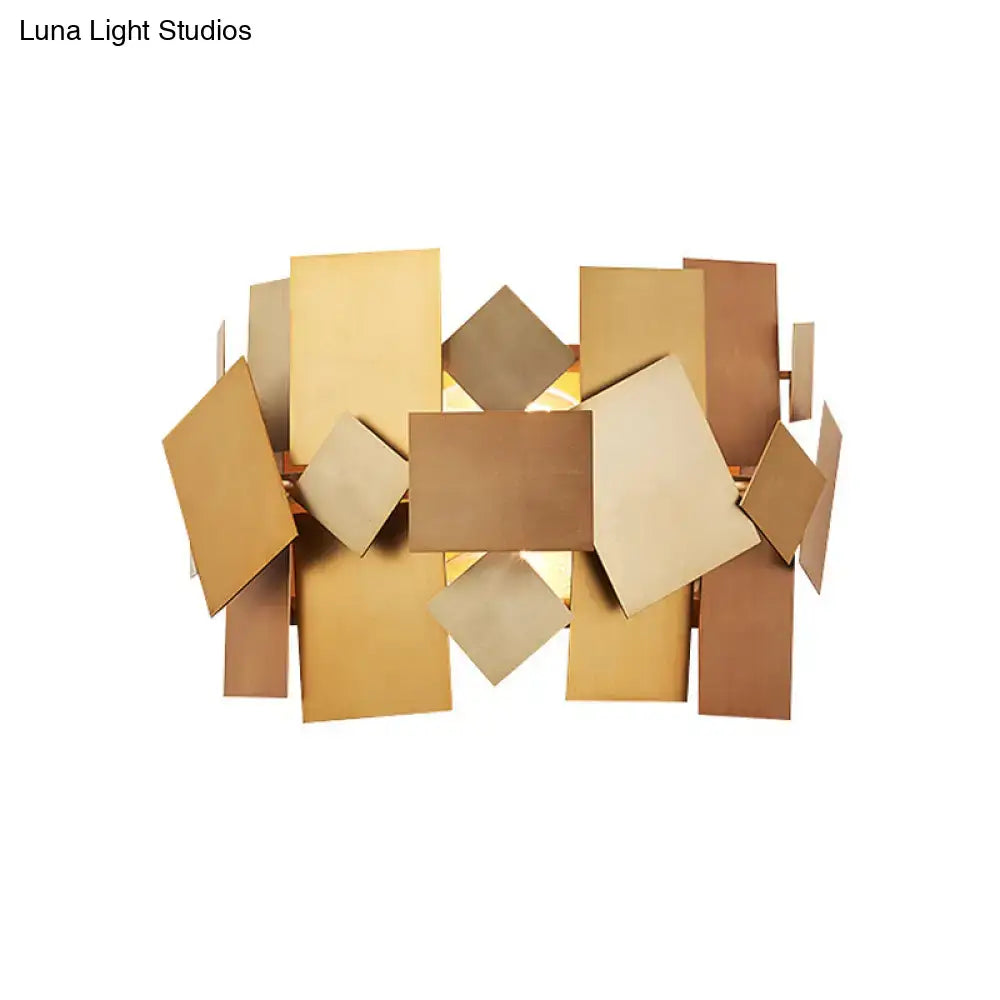 Modern gold-toned metallic sconce light fixture with geometric layered rectangular and diamond-shaped panels for living room