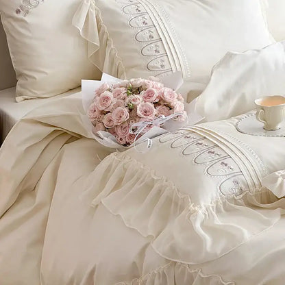 A delicate bouquet of soft pink roses complements the cream princess wedding bedding set with decorbites flowers embroidery