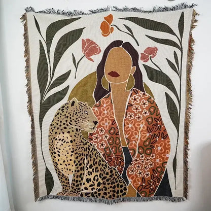 Beige woven ethnic tapestry sofa blanket featuring a woman in an orange floral jacket beside a leopard with floral motifs
