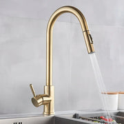 Brass-finished pull-down single hole kitchen mixer tap with sleek curved spout and single lever for hot water control