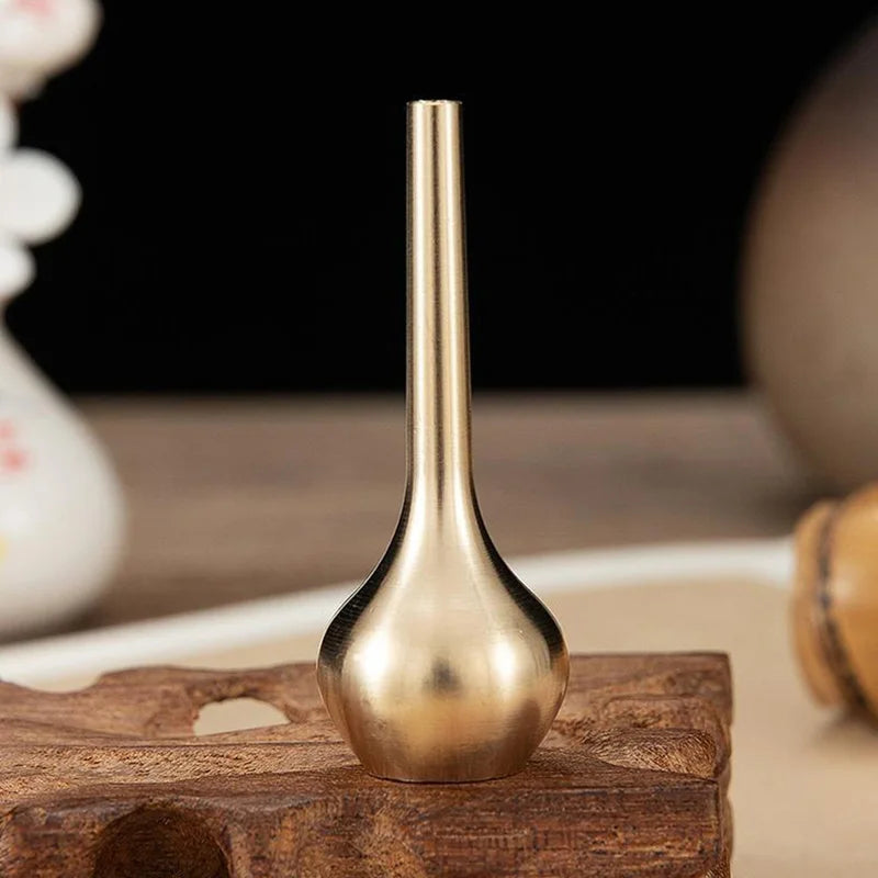 A sleek brass-colored pure copper mini vintage vase with a slender neck and rounded base for home decoration