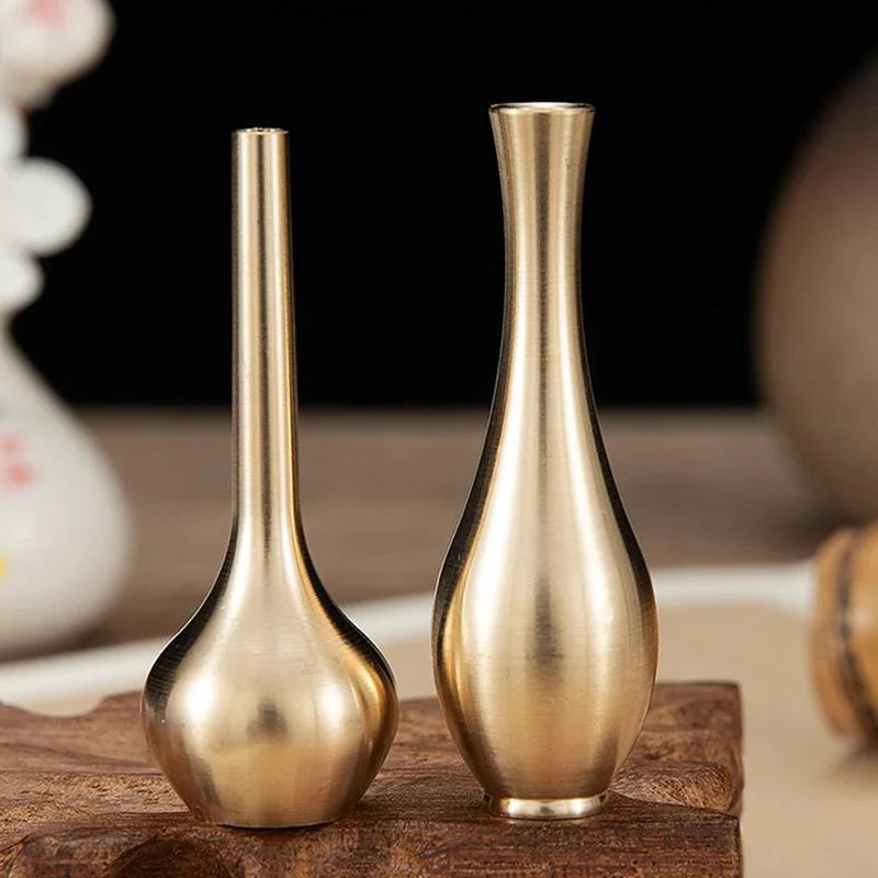Two elegant brass mini vases with slender necks and rounded bases for modern luxury home decoration