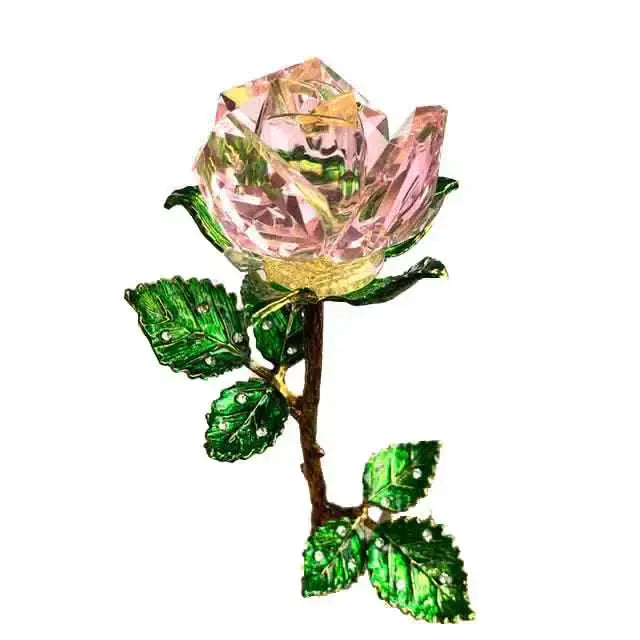 A sparkling pink crystal rose figurine brooch with green enamel leaves and a gold-toned stem for decoration