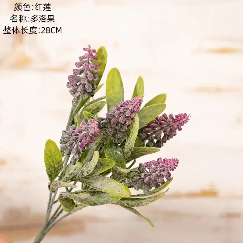 A synthetic purple and white lavender sprig with delicate blossoms and glossy leaves in a fake green plants bouquet