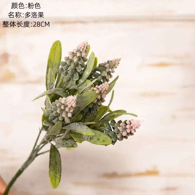 A delicate fake green plants bouquet with soft pink blossoms and frosted leaves for wedding decor