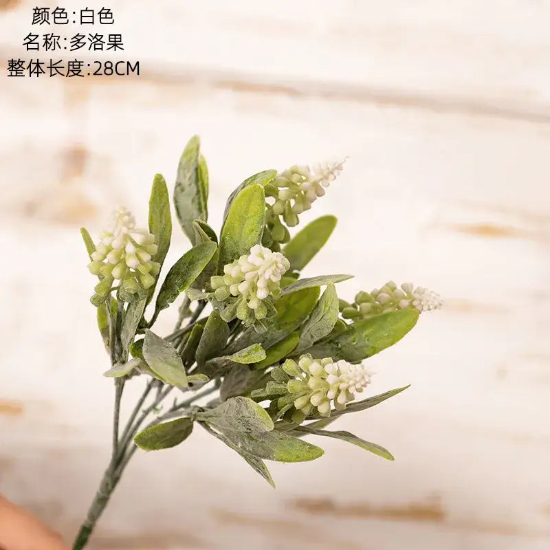 A delicate purple and white lavender fake green plants bouquet with artificial white muscari and green leaves for wedding decor