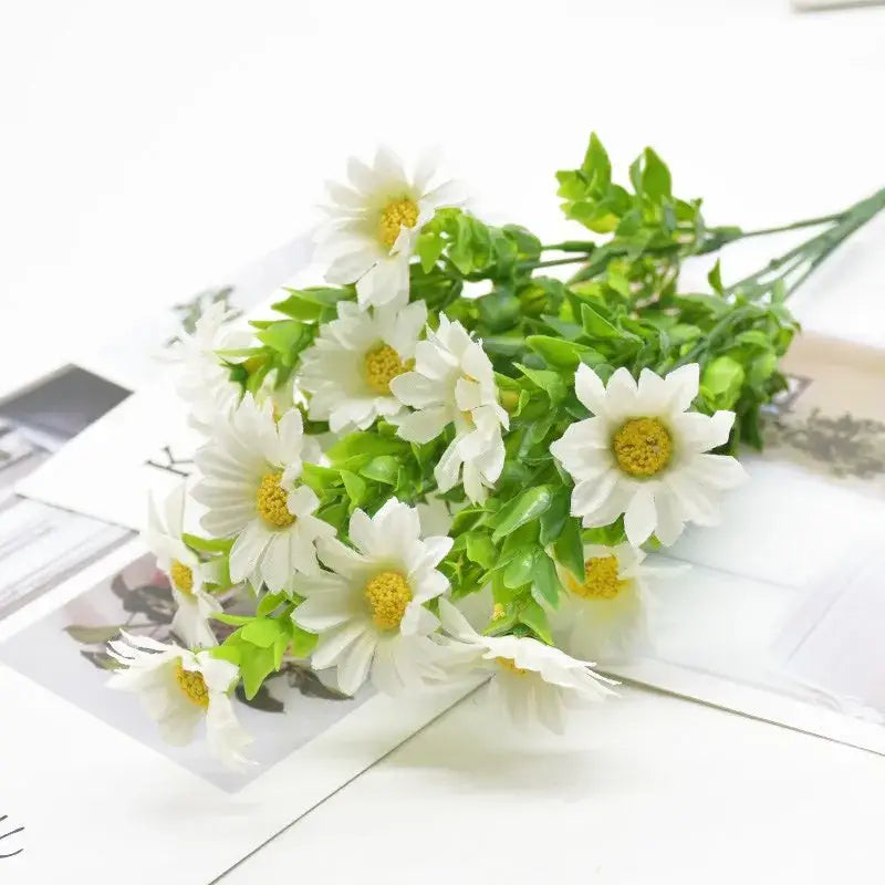 Artificial white daisies with yellow centers in a green plant synthetic bouquet for living room decor