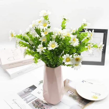 A daisy bouquet green featuring artificial white daisies with yellow centers in a pink geometric ceramic vase
