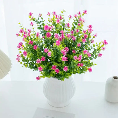 A vibrant pink decorbites artificial eucalyptus plant with lush green leaves in a white ceramic vase for decor